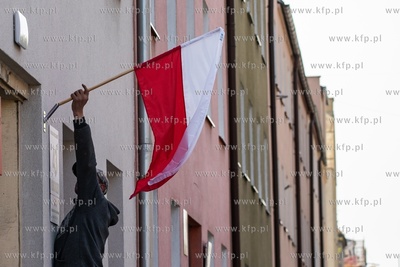 Gdańsk Wrzeszcz.  Mężczyzna montuje flagę Polski...