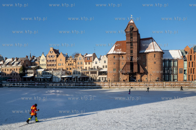 Spacerowicze na skutej lodem Motławie w Gdańsku....