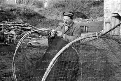 Czesław Żukowski , rybak znad Zalewu Wiślanego naprawia...