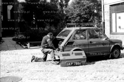 Mezczyzna naprawia samochod marki Fiat 126p popularnie...