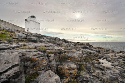 Irlandia. Latarnia morska osadzona na surowych skalach...