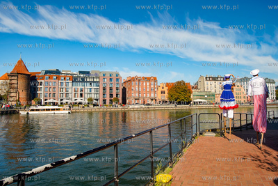Szczudlarze na Wyspie Ołowianka. W oddali kamienice...