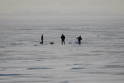 Kuznica. Ludzie spaceruja po zamarznietej zatoce puckiej....