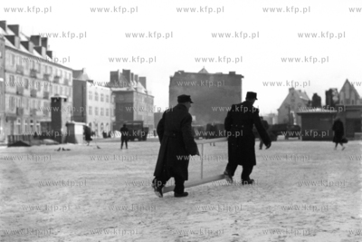 Dwóch mężczyzn z oknem maszerują przez plac Dominikański...