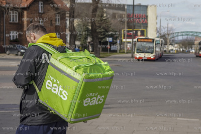Dostawca Uber Eats czeka na odbiór zamówienia z bistro...