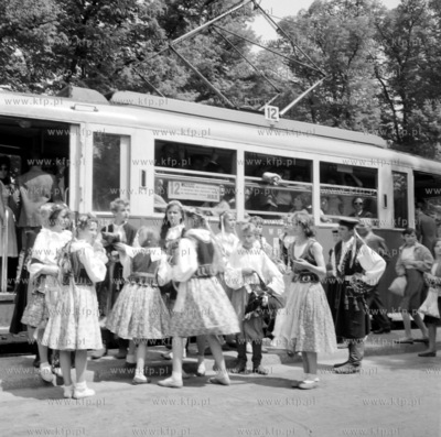 Zespol ludowy wsiada do tramwaju linii 12 na przystanku...
