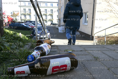 Puste butelki po piwie leżące przed schodami pomiędzy...