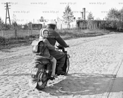 Dziecko wraca ze szkoly na motorze po brukowej drodze...