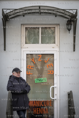 Kolejny klient czeka pod zakładem fryzjerskim przy...