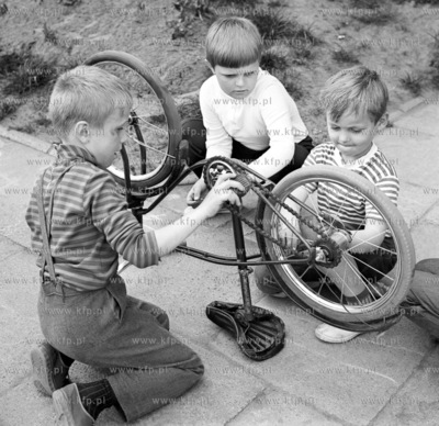 Dzieci poznaja tajniki rowerka przed jeddnym z blokow...