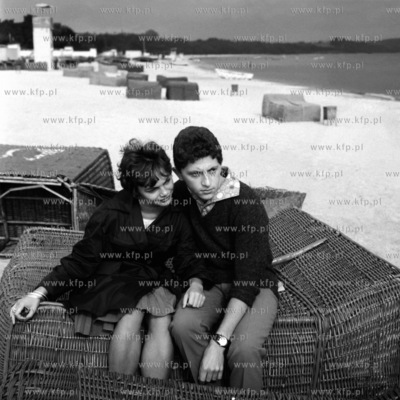 Młodzi ludzie siedzą na plażowych koszach w Sopocie.1964....