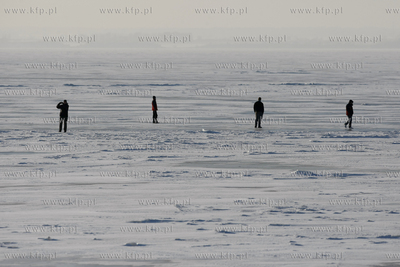 Kuznica. Ludzie spaceruja po zamarznietej zatoce puckiej....