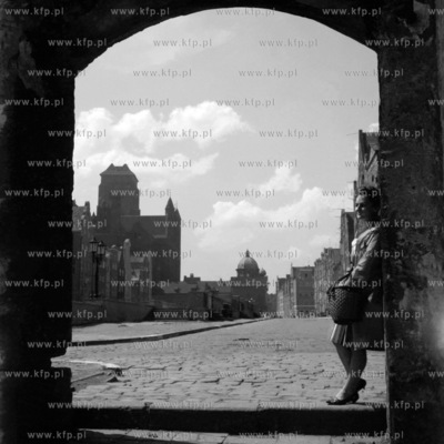 Kobieta stoi w bramie Świętego Ducha w Gdańsku....