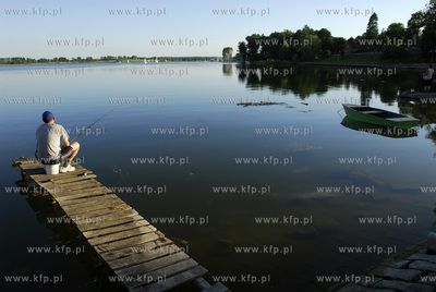 Ryn. Wedkarz na pomoscie i przystan zeglarska na Jeziorze...