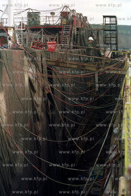 Stocznia Gdynia, budowany statek w doku, przewody do...