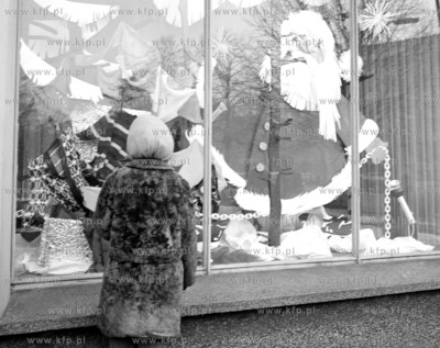 Dziecko przed switeczna wystawa sklepowa ze smutnym...