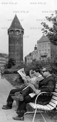 Mezczyzni czytaja gazety na lawce na skwerze pomiedzy...