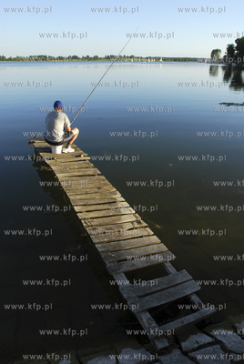 Ryn. Wedkarz na pomoscie i przystan zeglarska na Jeziorze...