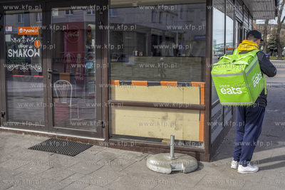 Dostawca Uber Eats czeka na odbiór zamówienia z bistro...