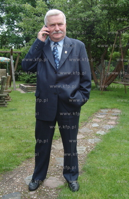 Lech Walesa rozmawia przez telefon komorkowy w ogrodzie...