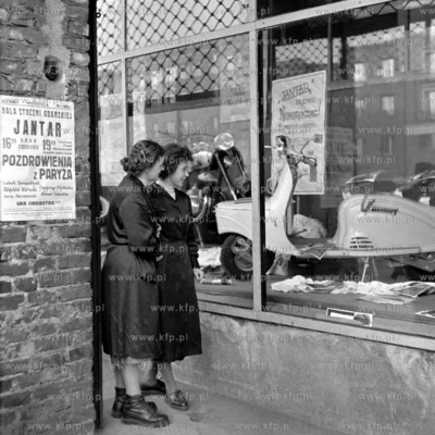 Kobiety przyglądają sie stojącemu w witrynie sklepowej...