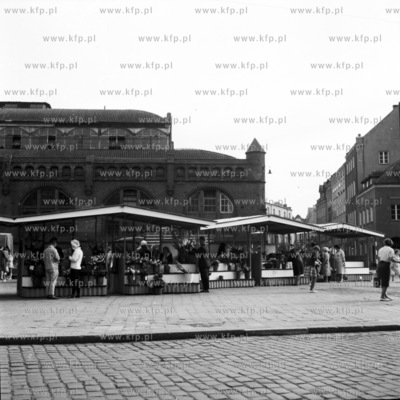 Stragany z kwiatami na placu przed Hala Targową przy...