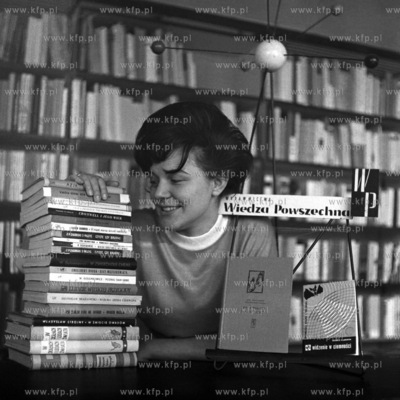 Kobieta prezentuje książki wydane przez wydawnictwo...