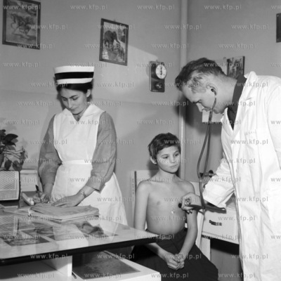 Lekarz Jan Babicki podczas badania młodego pacjenta...