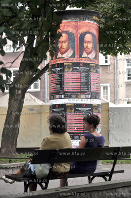 Slup ogloszeniowy oblepiony plakatami reklamujacymi...