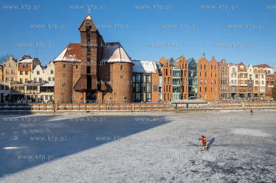 Spacerowicze na skutej lodem Motławie w Gdańsku....