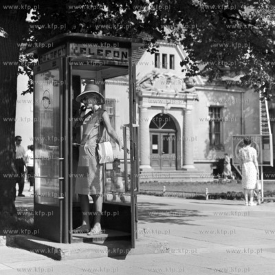 Kobieta rozmawia przez telefon w budce telefonicznej...