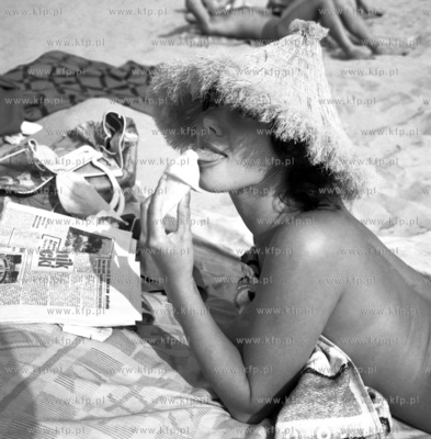 Dziewczyna z lodem i gazeta Dziennik Baltycki na plazy...