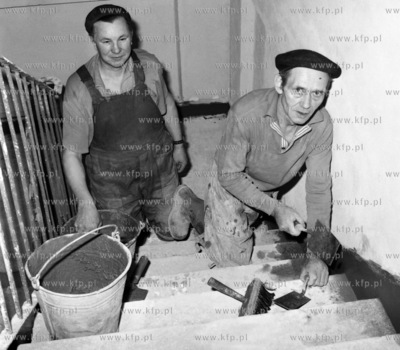 Robotnicy podczas pracy na klatce schodowej domu na...