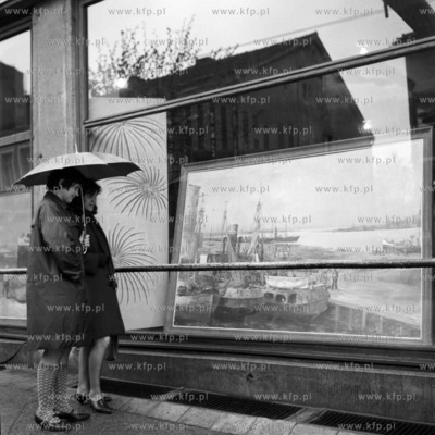 Kobiety przyglądają się obrazowi w witrynie sklepowej....