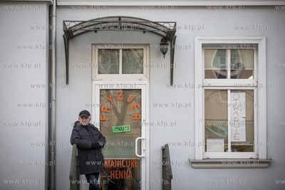 Kolejny klient czeka pod zakładem fryzjerskim przy...
