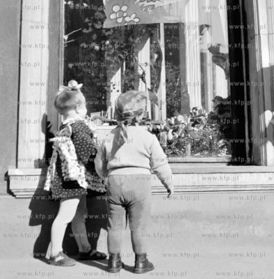 Dzieci przed  wystawa sklepu z zabawkami lub slodyczami...