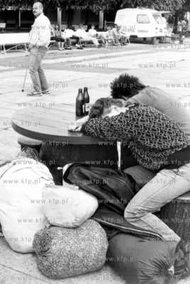 Zmeczeni mlodzi ludzie spia w poblizu mola w Sopocie....