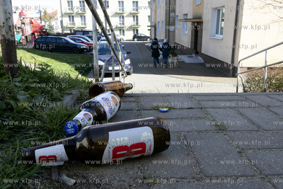 Puste butelki po piwie leżące przed schodami pomiędzy...