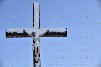 Zima w Żukowie na Kaszubach. Ośnieżony krzyż  przy...