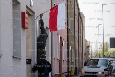 Gdańsk Wrzeszcz.  Mężczyzna montuje flagę Polski...