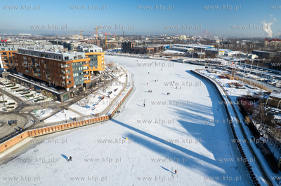 Spacerowicze na skutej lodem Motławie w Gdańsku....