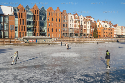 Spacerowicze na skutej lodem Motławie w Gdańsku....