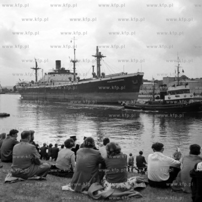 Publiczność przyglda się wpłynięciu do portu statku...