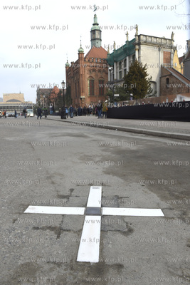 Lampa w kształcie krzyża zamontowana w asfaltowej...