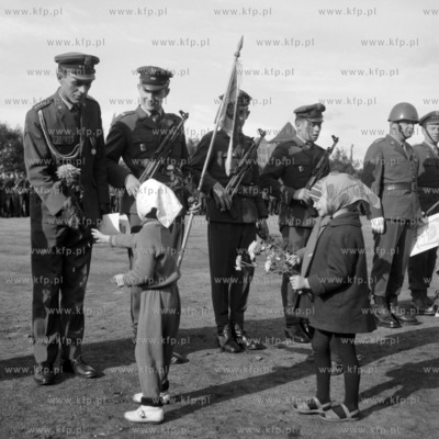 Dzieci wręczają kwiaty żołnierzom podczas przysięgi...