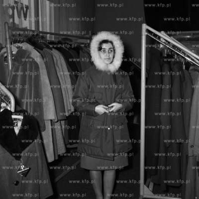 Sprzedawczyni w sklepie z odzieżą prezentuje zimowy...