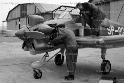 Mechanicy dokonują przeglądu silnika samolotu na...