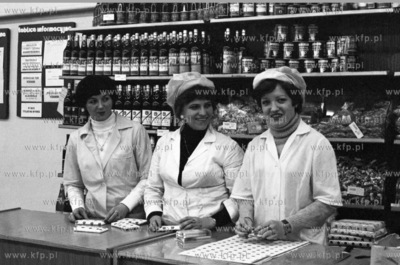 Personel sklepu na stoisku z winem i slodyczami. Prosimy...