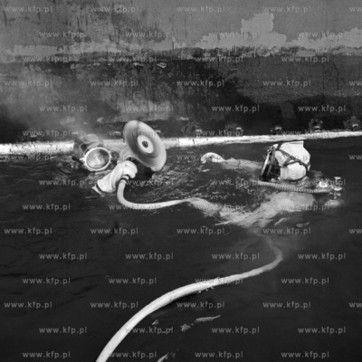 Płetwonurek Jan Osmański  konserwuje kadłub statku...