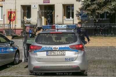 Samochody policyjne stojące przed budynkiem komendy...